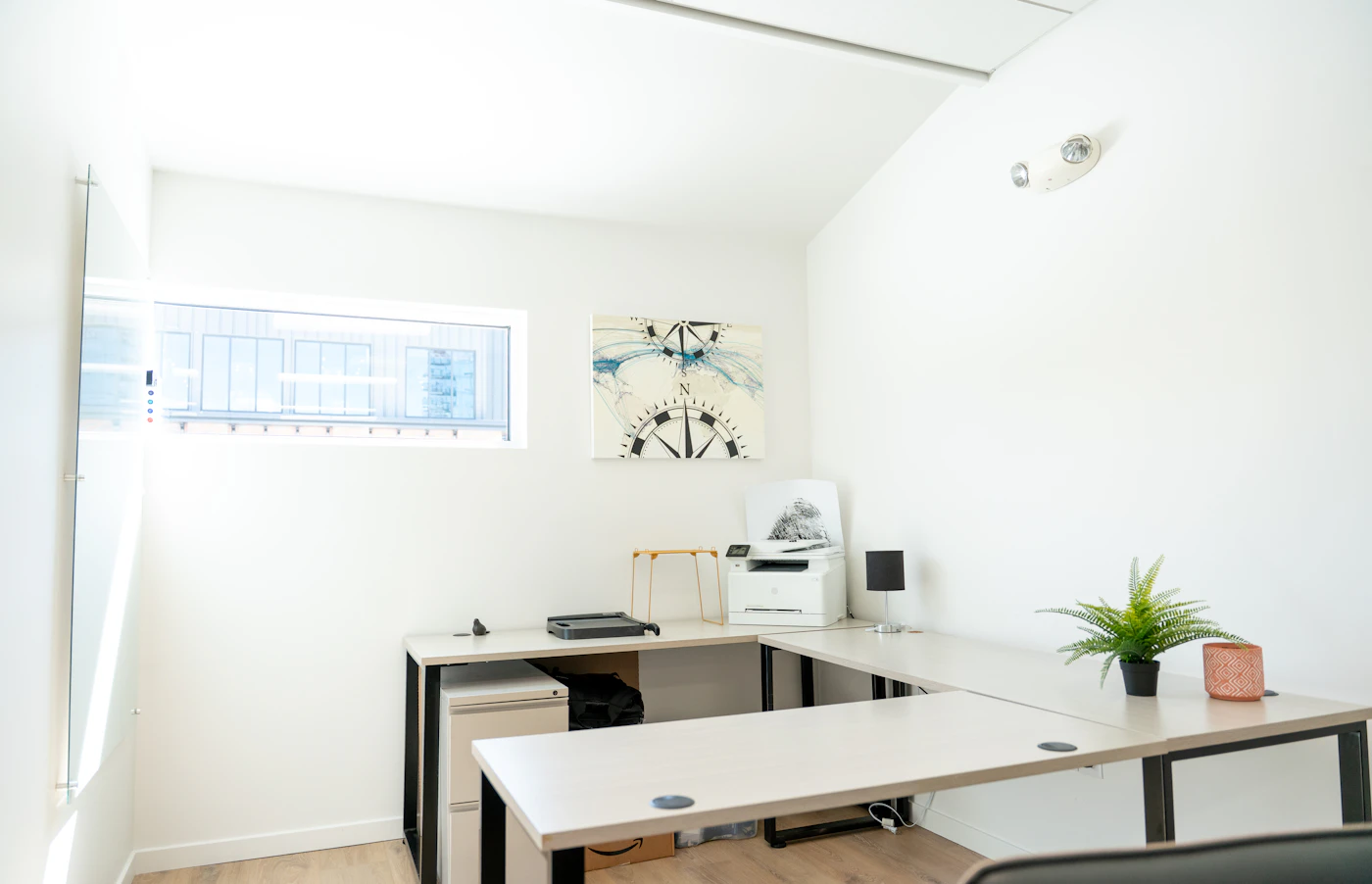 Oficina con luz natural, escritorio y pizarra preparada para el trabajo